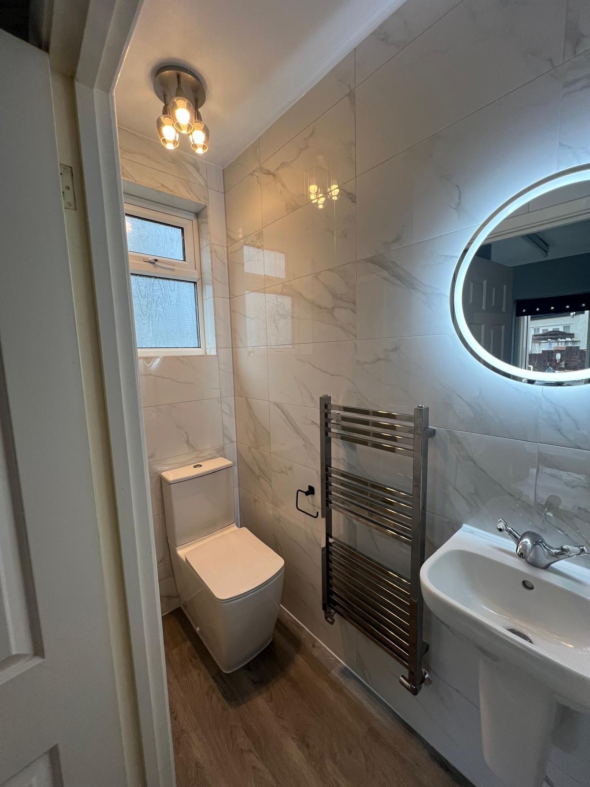 Backlit mirror and basin in compact shower room