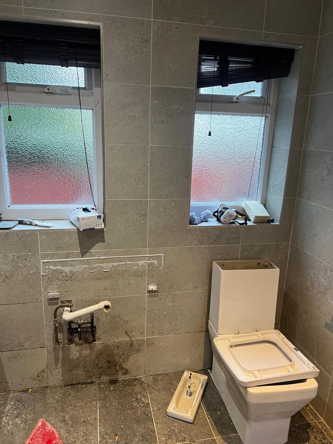 Green and white bathroom transformation before renovation