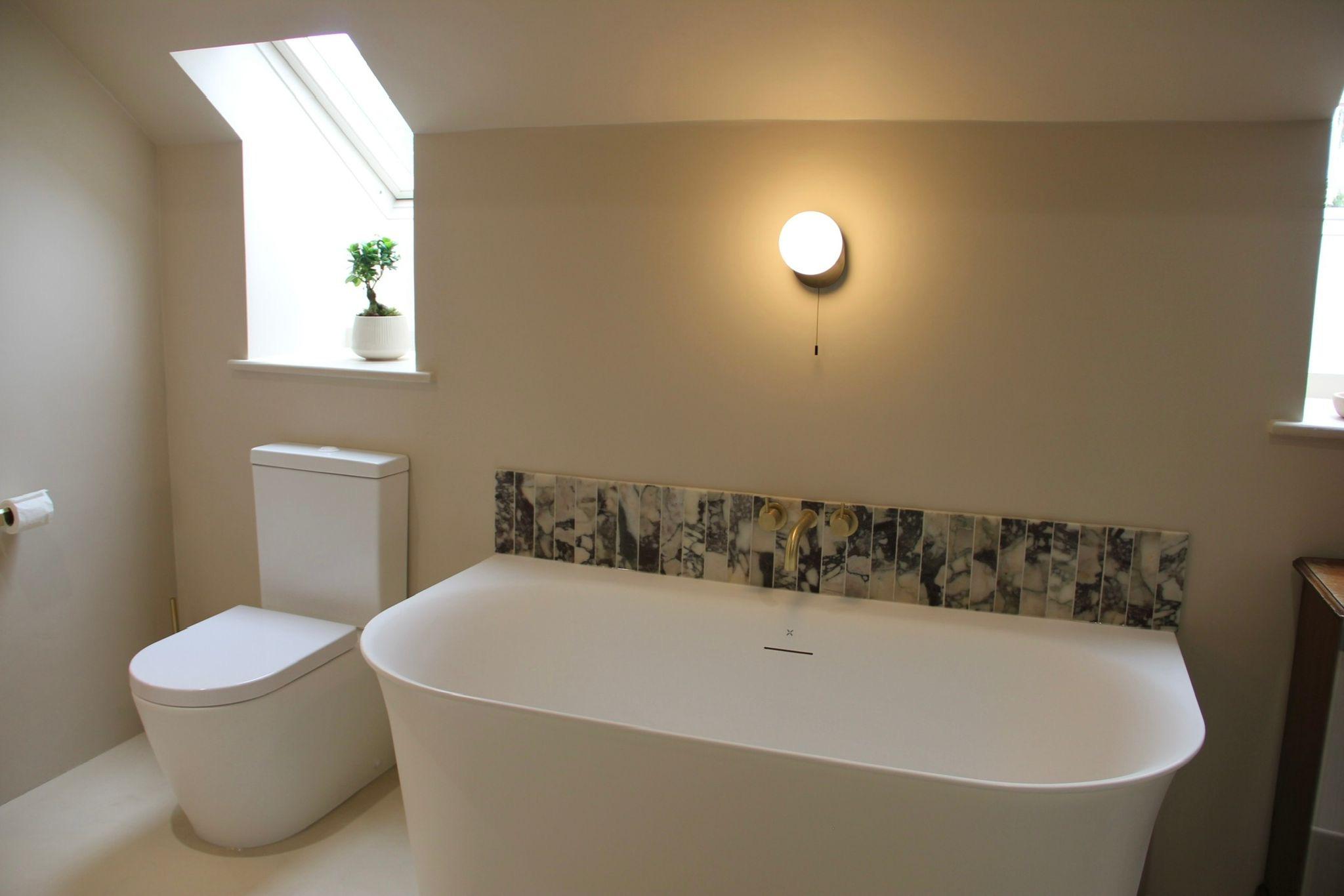 Freestanding bath beside roof window