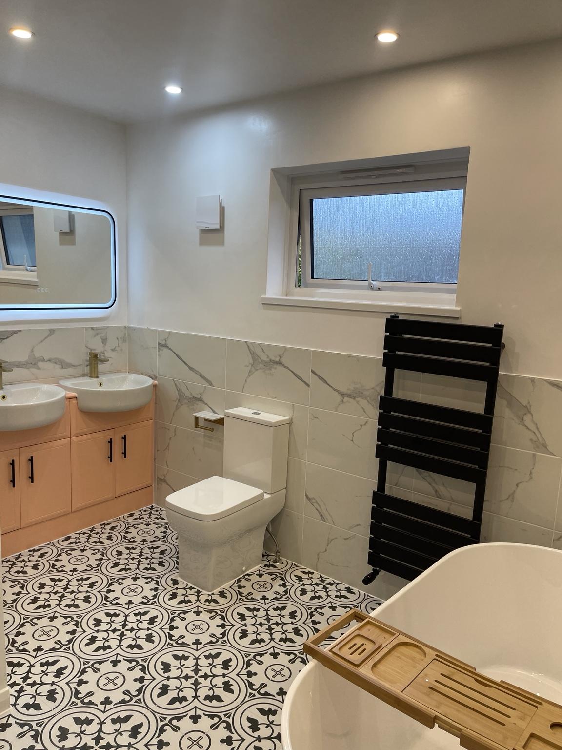 Freestanding bath and double vanity on patterned flooring