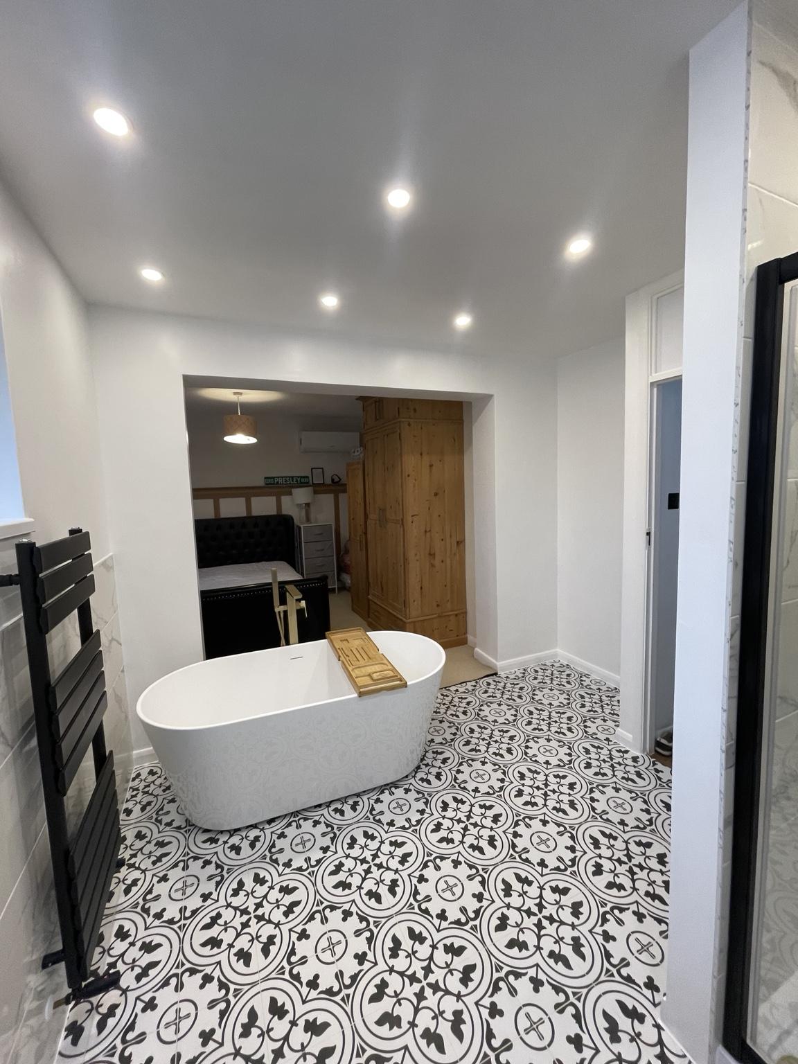 Freestanding bath beside the open bedroom