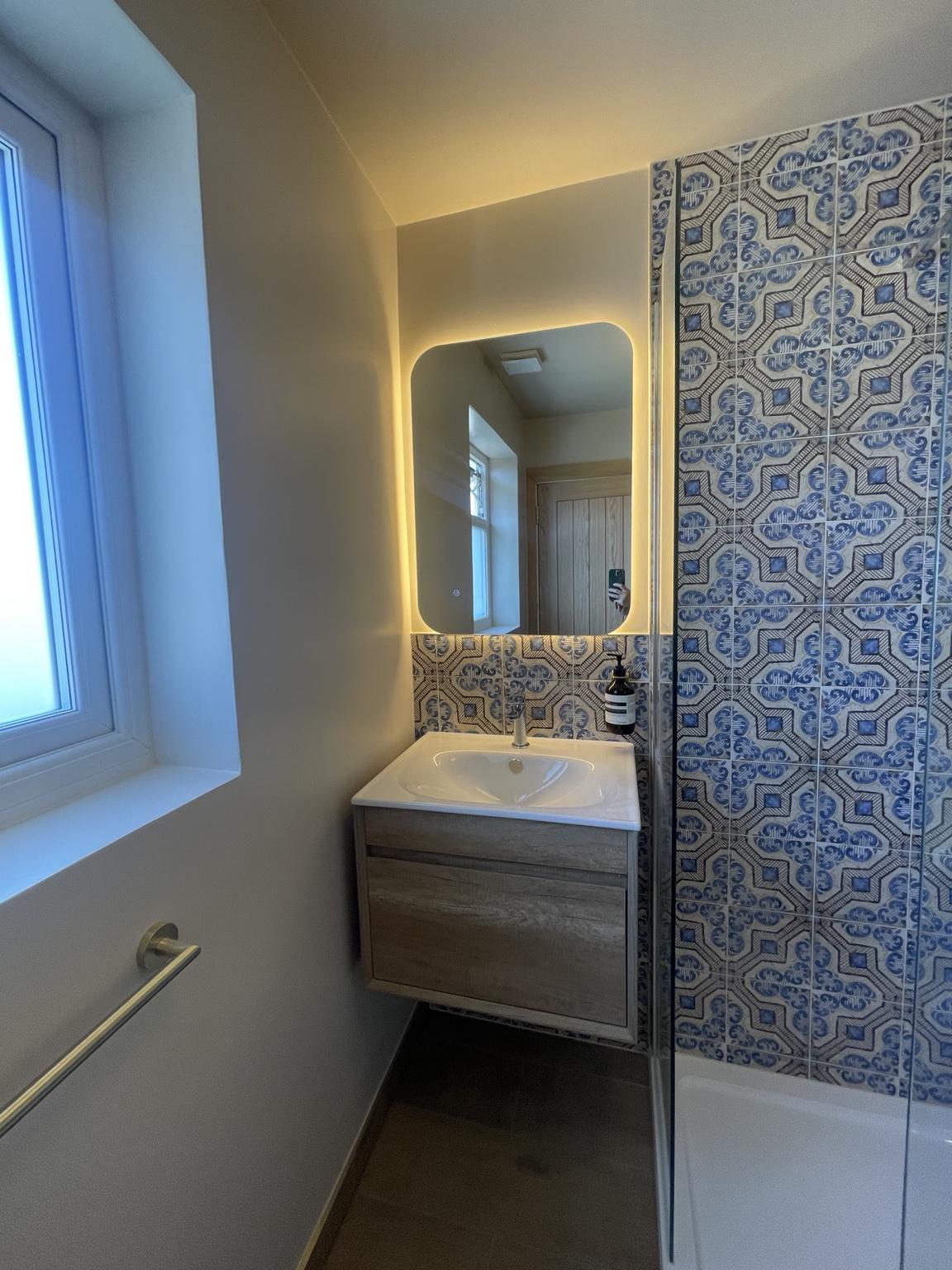 Backlit bathroom mirror and wood-effect vanity