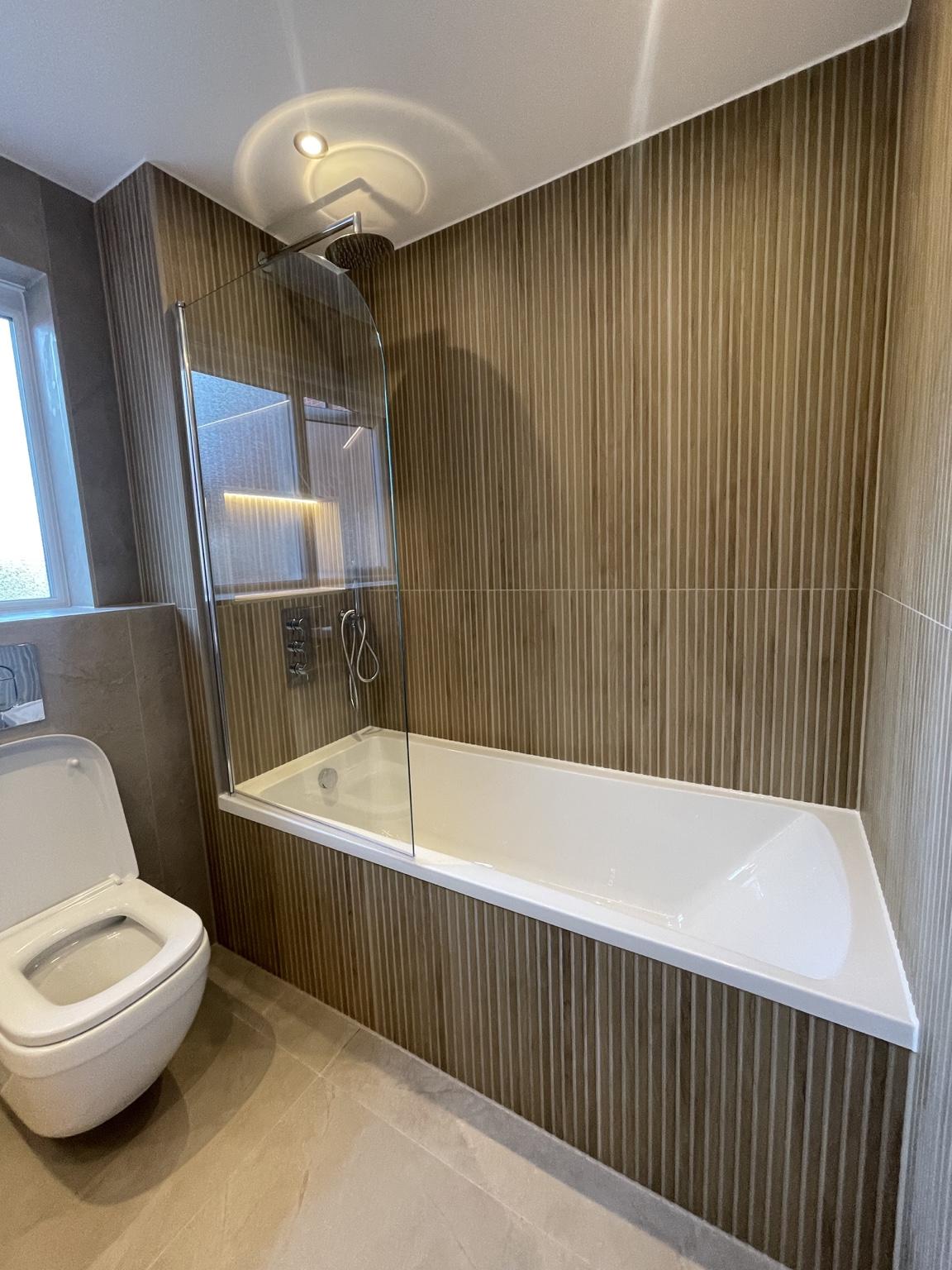 Bath and shower with wood-effect wall tiles